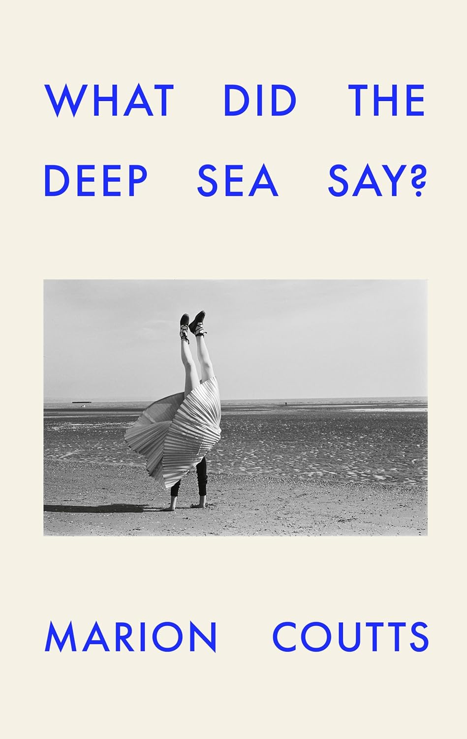 Cover of "What Did the Deep Sea Say?" by Marion Coutts features a black-and-white photo of a person doing a handstand on a beach, with blue text.