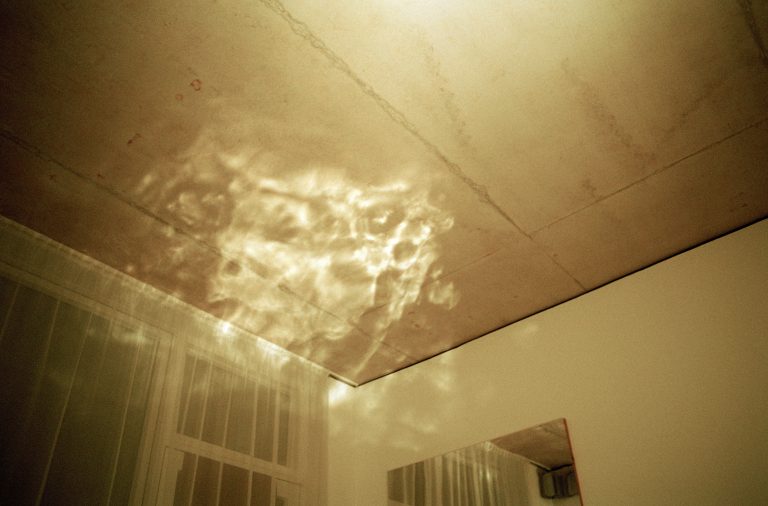 Looking up towards the ceiling of a domestic room, a cloud of light floats above our heads.