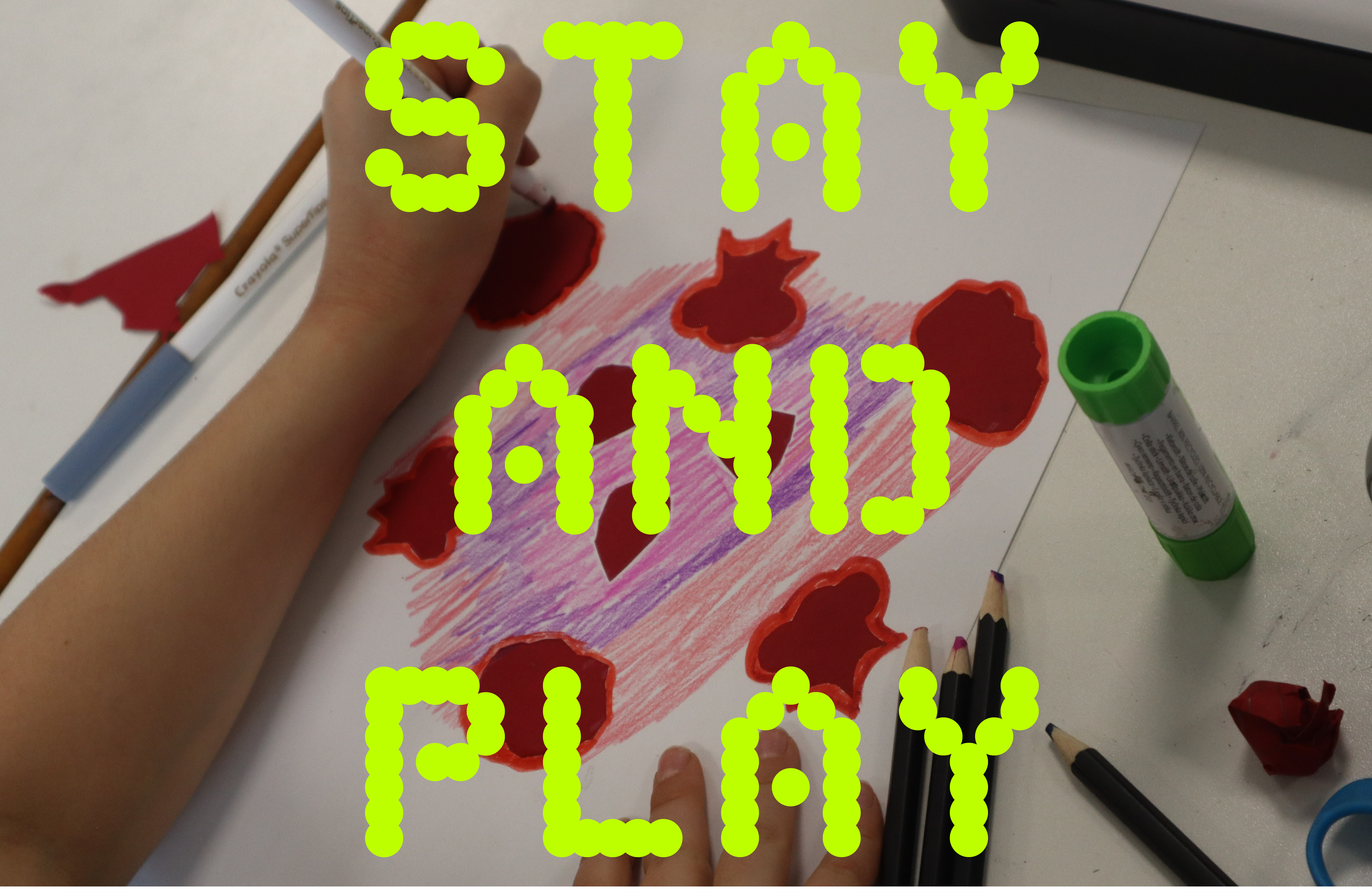 A child hand drawing red shapes on paper with a red felt tip pen. The words STAY AND PLAY are written over the top in a bold, lime green font.